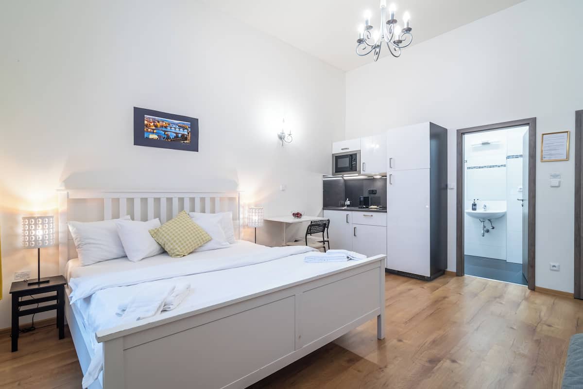 Una camera da letto moderna con un letto, comodini, una scrivania e un angolo cottura.