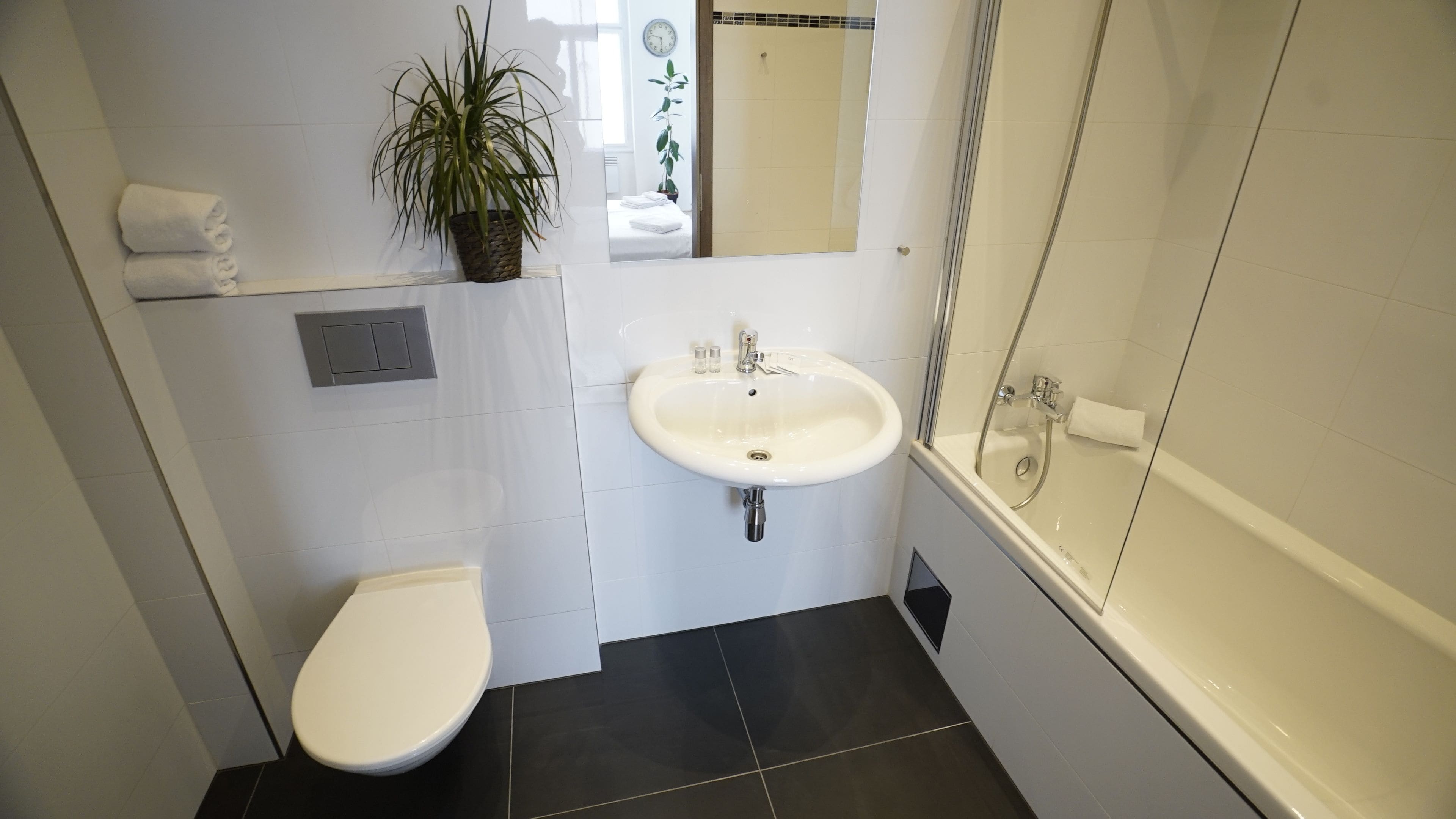 A bathroom with a toilet, sink, and bathtub.
