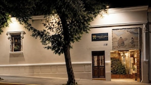 A building with a sign reading 'CASA DE AVILA NOSTREDA', a door, and a window with a plant. - Casa de Avila Hotel (Arequipa)
