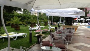 Outdoor seating with umbrellas, lounge chairs, and a pool area. - Flamingo (Nessebar)