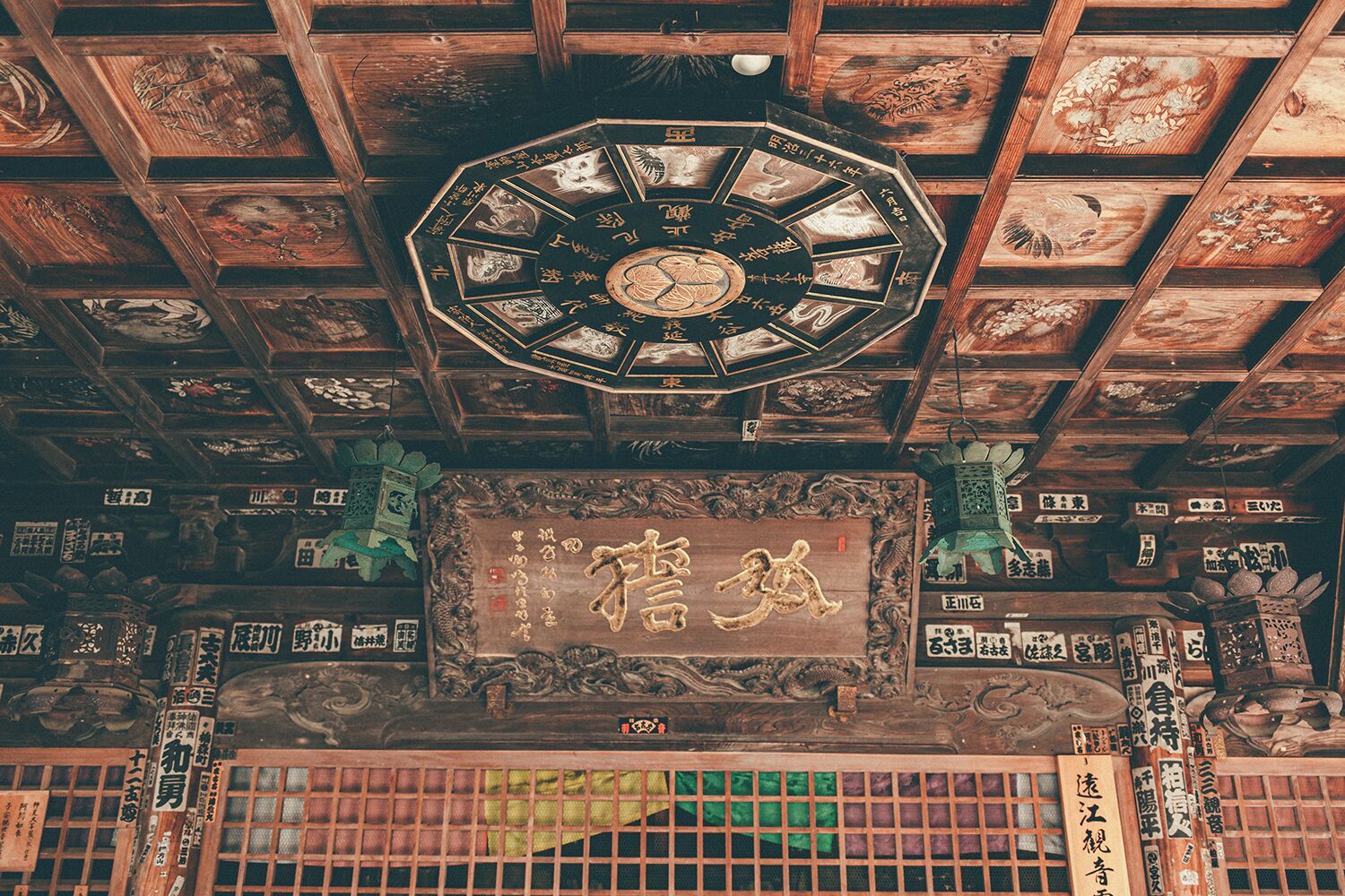 Un interior japonés tradicional con techo de madera que presenta intrincadas tallas y un reloj central.
