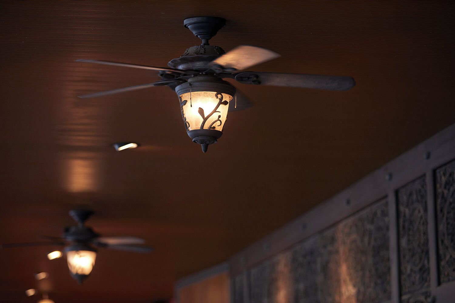 Un ventilador de techo con una lámpara decorativa.