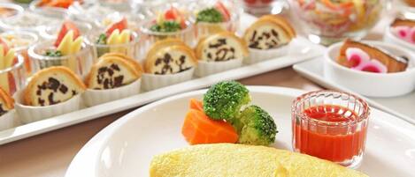 A plate with an omelette, broccoli, and carrot slices, accompanied by a glass of ketchup.