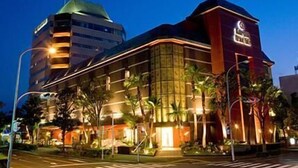 Um hotel com design moderno, apresentando uma entrada destacada com fachada curva e um grande letreiro.