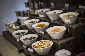 A breakfast buffet with various food items in bowls, each labeled with a name tag. - Wellness Hotel Casa Barca - Adults Only (Malcesine)