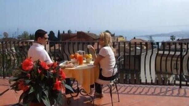 A couple dining at a table with a view of the sea. - Mamma Maria (Taormina)