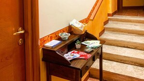 Un mostrador de recepción con un letrero de bienvenida, una escalera y una puerta.