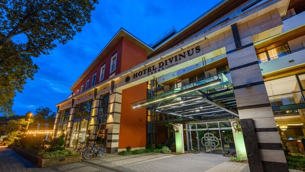 A modern hotel with a prominent entrance, a covered walkway, and a well-lit facade.
