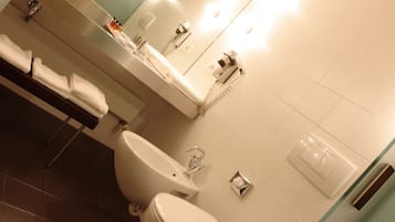 A modern bathroom with a toilet, sink, and mirror.