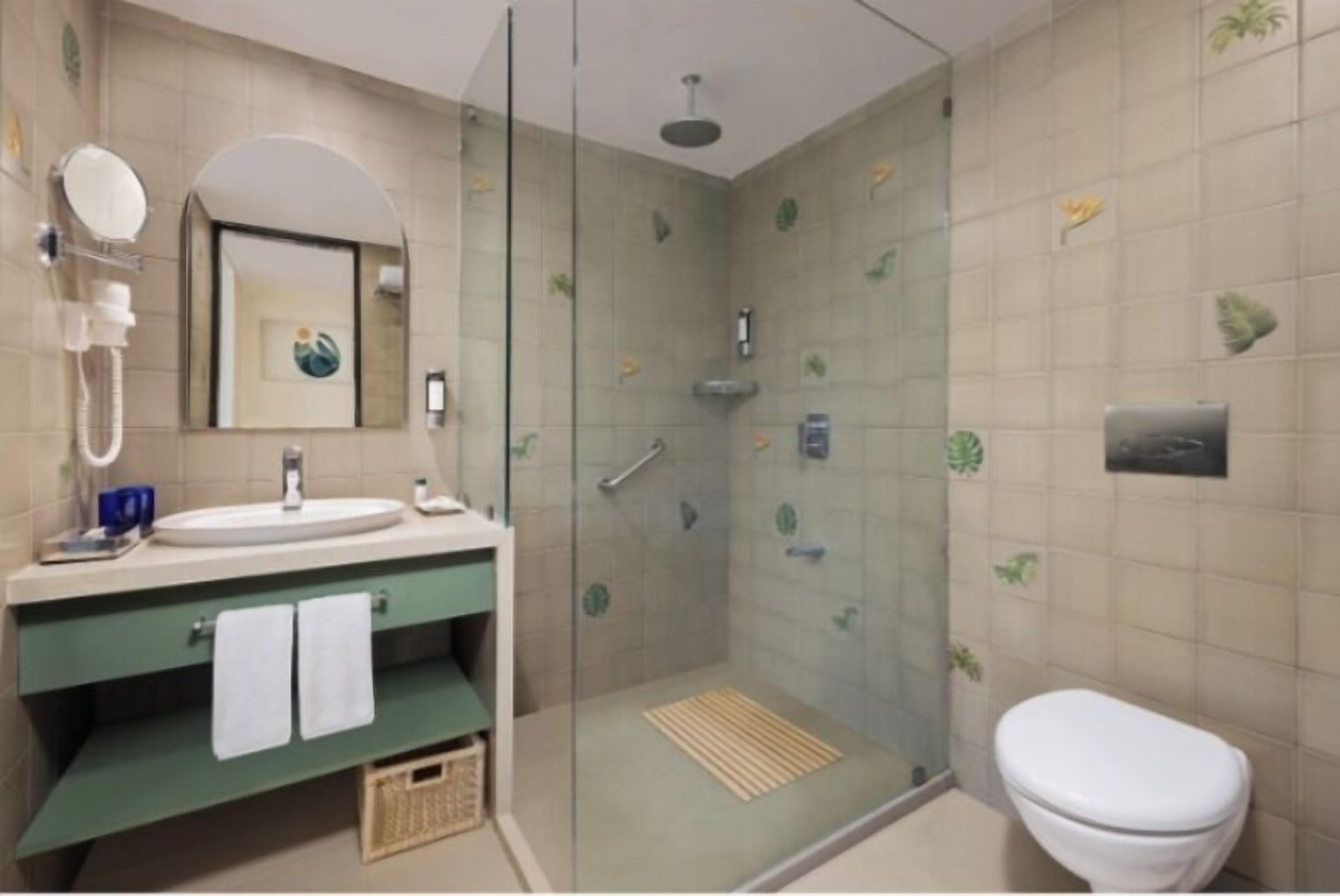 A modern bathroom with a glass-enclosed shower, a sink with a mirror, and a toilet.