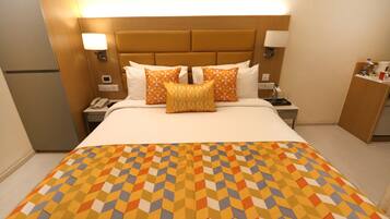 Une chambre d’hôtel avec un grand lit, une table de chevet avec une lampe et une petite table de nuit avec un téléphone.