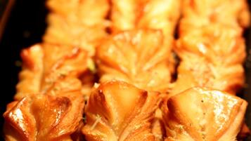 Una bandeja con pastelería horneada y corteza dorada, dispuesta en filas.