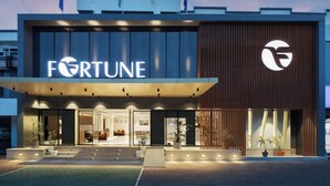 Un bâtiment moderne arborant fièrement le logo de Fortune, avec une façade en verre et une partie recouverte de panneaux en bois.