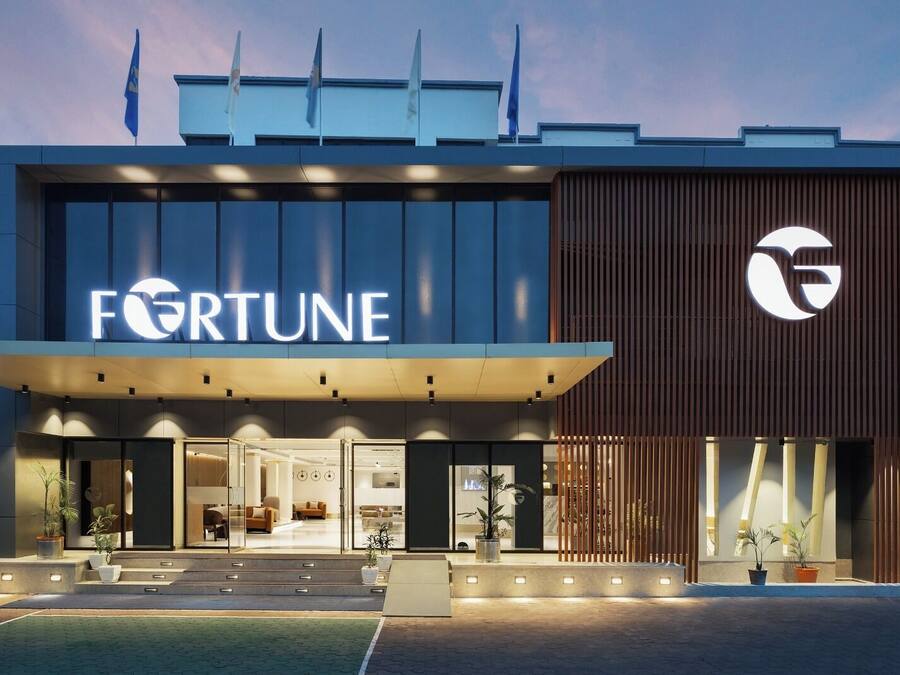 Un edificio moderno con el logotipo destacado de Fortune, con fachada de vidrio y una sección de paneles de madera.