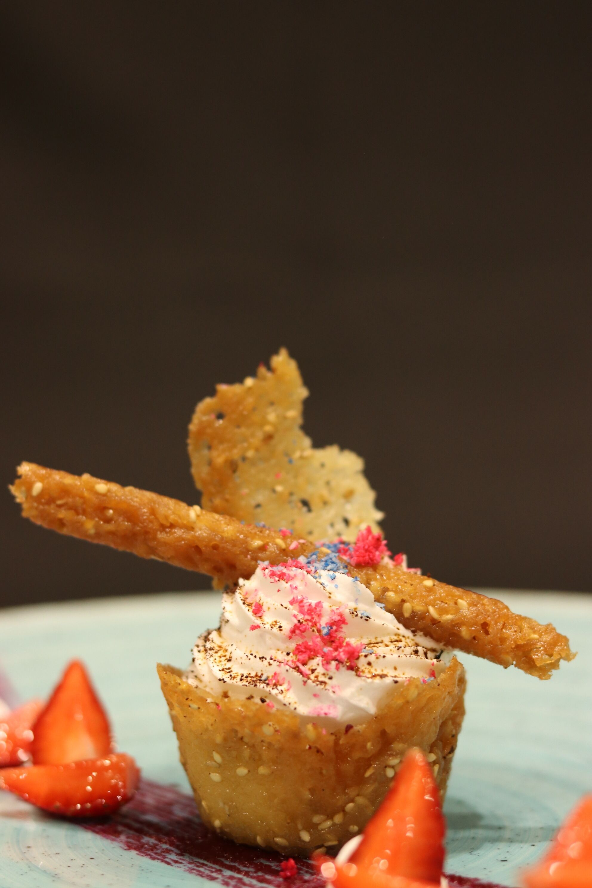 A dessert with whipped cream and colorful sprinkles on a plate.