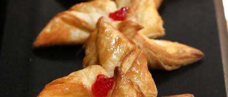 A row of pastries on a black tray.