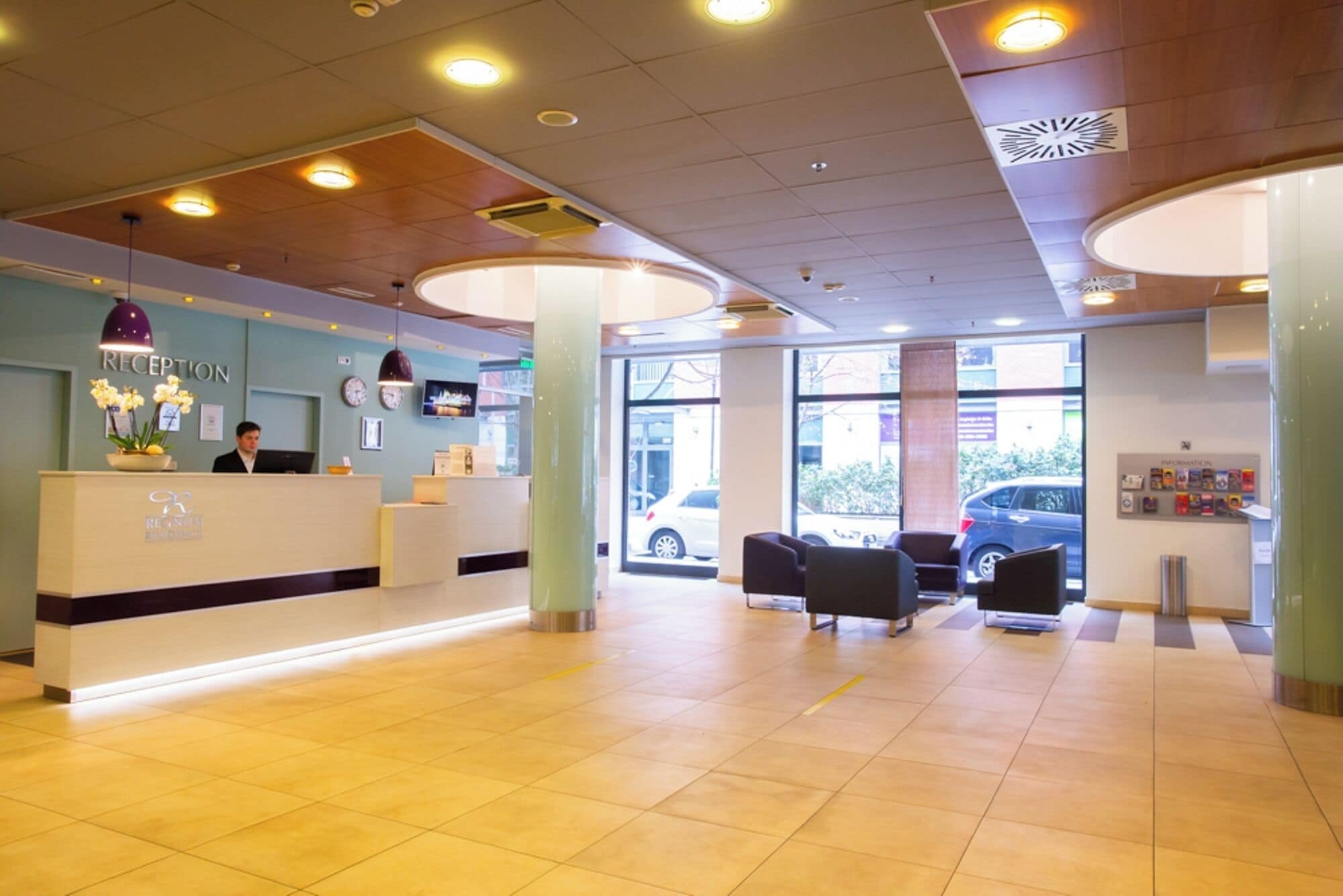 A reception area with a reception desk, chairs, and a large window providing a view of the street.