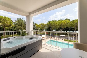 Un balcone con idromassaggio, piscina e area relax all'aperto.