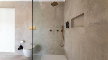 Une salle de bain moderne avec une douche à parois de verre, des toilettes et un lavabo.