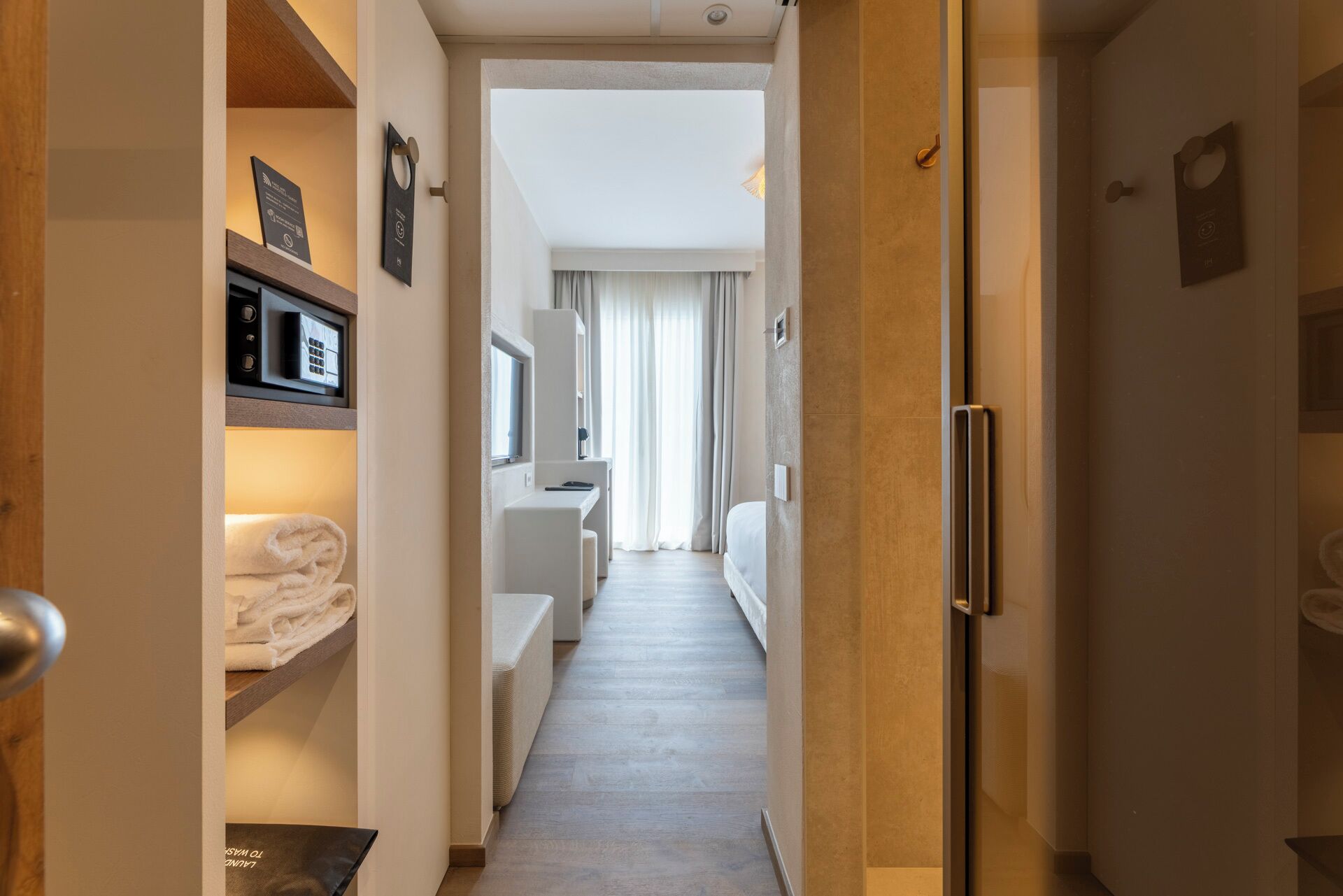 Ein Hotelgang mit einem Bett, einem Schreibtisch und einem Kühlschrank.