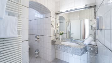 Ein modernes Badezimmer mit einem Doppelwaschbecken, einem großen Spiegel und einem Handtuchhalter.
