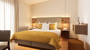 A hotel room with a large bed, two bedside tables with lamps, a wooden nightstand, a chair, and a small stool. - Galerie Hotel Bad Reichenhall (Bad Reichenhall)