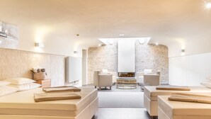 Un moderno spa con dos camillas de masaje, una chimenea y una pared de ladrillo.