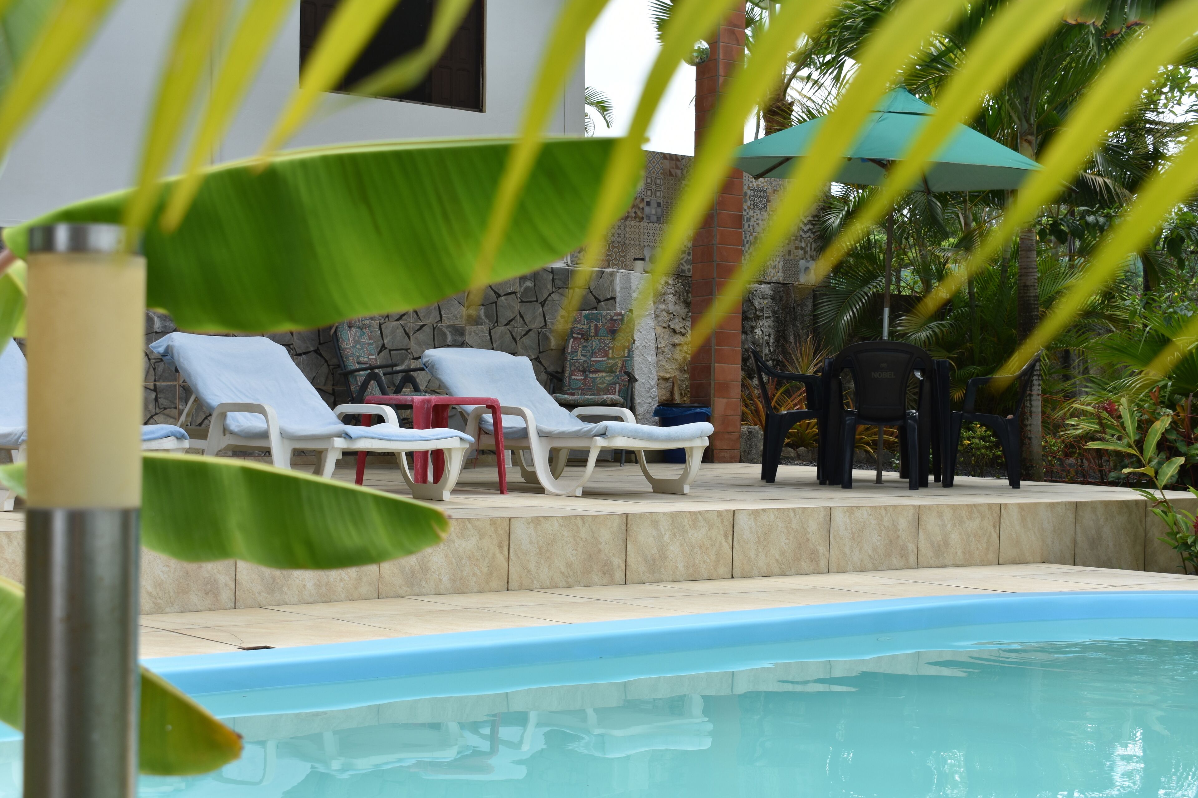 Een buitenzwembad, parasols voor strand/zwembad