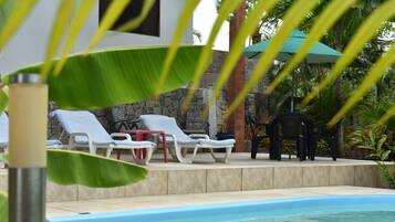 Een buitenzwembad, parasols voor strand/zwembad