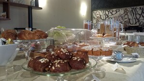 Eine Bäckereireihe mit verschiedenen Gebäcken und Brot, darunter Croissants und Muffins, verpackt in Plastik.