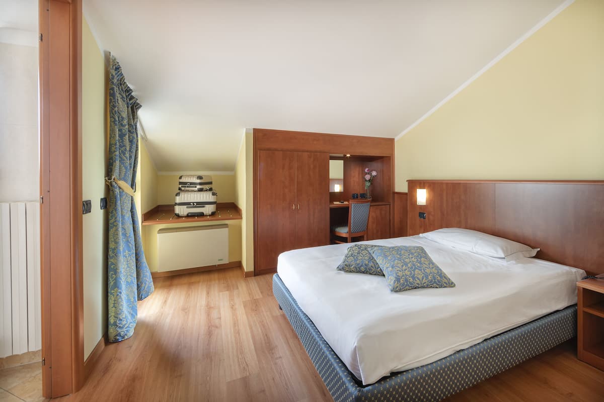 Une chambre à coucher avec un grand lit, une tête de lit en bois et un bureau avec une chaise.
