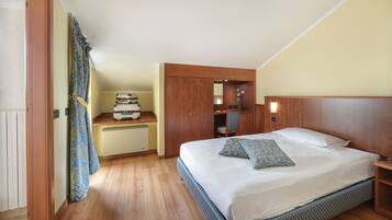 A bedroom with a large bed, wooden headboard, and a desk with a chair.