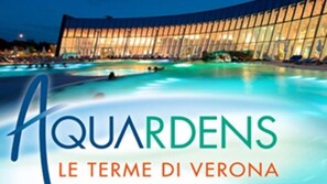 A hotel with a large pool and a modern glass facade.