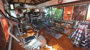Un gimnasio con cintas de correr, elípticas y pesas libres.