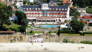 A hotel with a swimming pool, a beach, and a signboard.