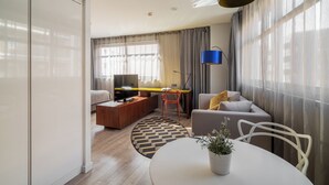 A modern living room with a sofa, a dining table, and a TV. - Naitly Barcelona Poblenou (Barcelona)