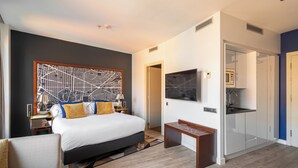 A modern hotel room with a large bed, a TV, a desk, and a walk-in closet. - Naitly Barcelona Poblenou (Barcelona)