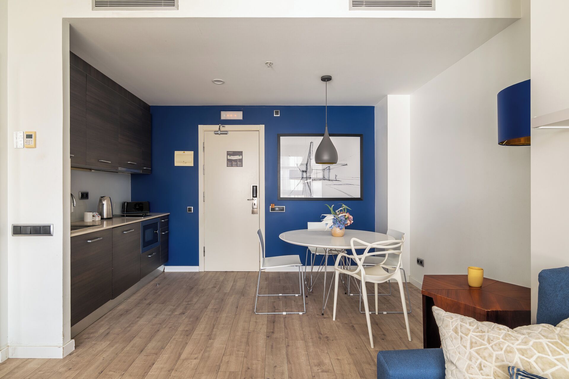 Una cocina moderna con gabinetes oscuros, una encimera blanca y un horno empotrado.