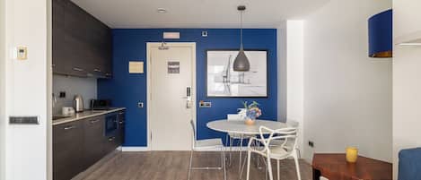 Una cocina moderna con gabinetes oscuros, una encimera blanca y un horno empotrado.