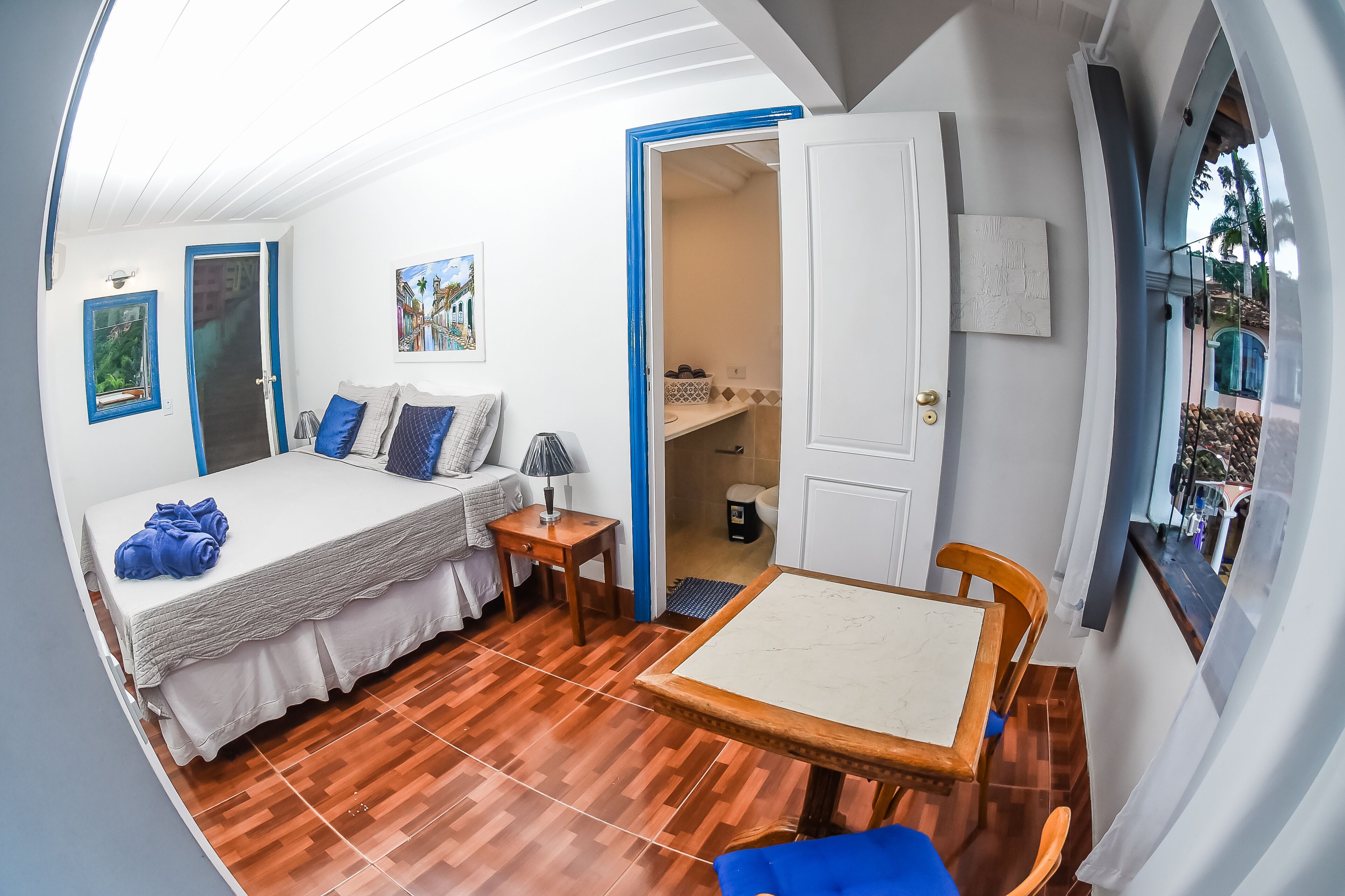 A bedroom with a bed, bedside table, and a small table with chairs.