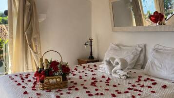 Un dormitorio con cama, mesita de noche, lámpara, ventana con vista y espejo en la pared.