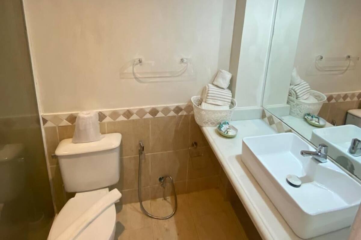 Une salle de bain avec des toilettes, une douche et un lavabo.