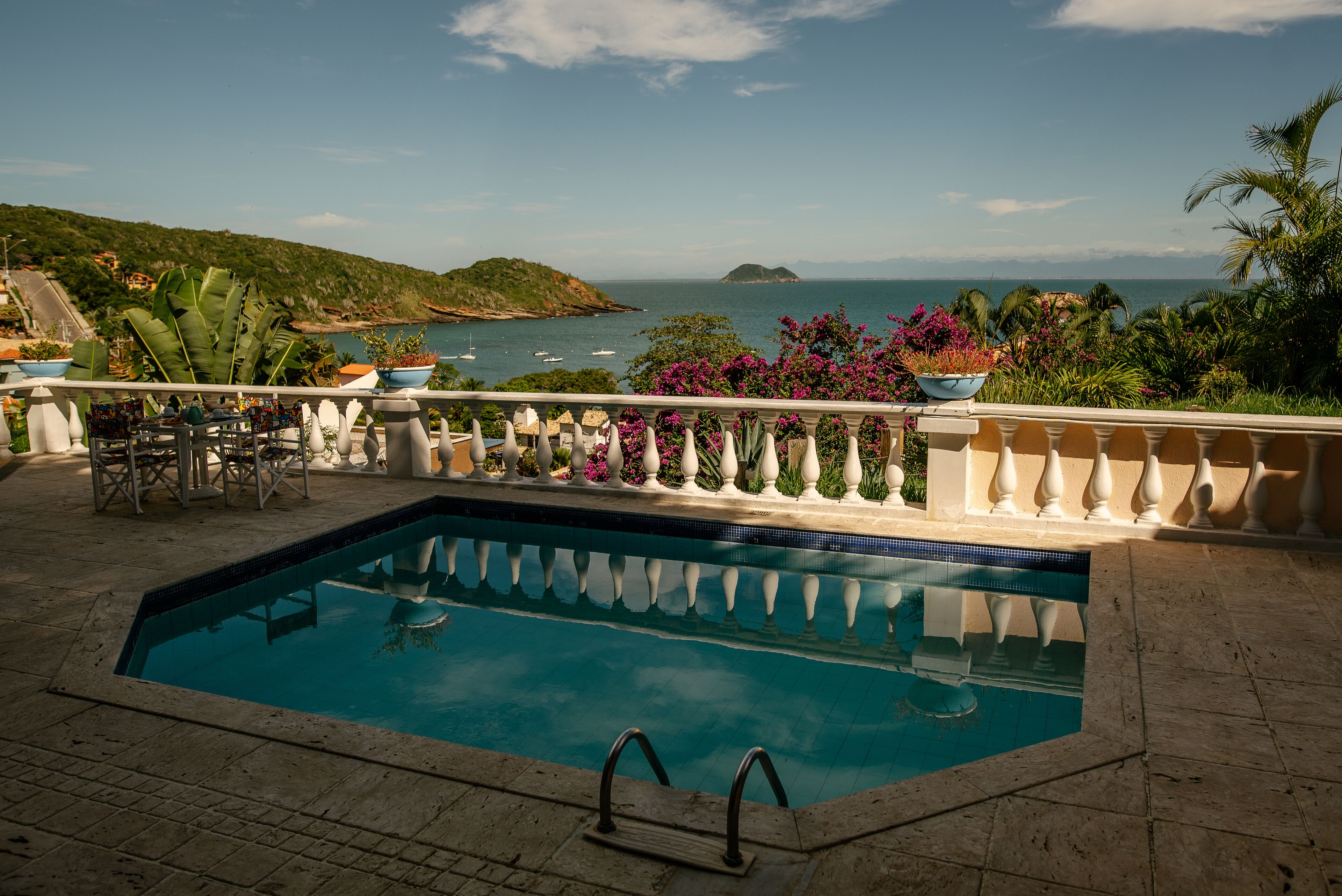 Una piscina al aire libre, sombrillas, sillones reclinables de piscina