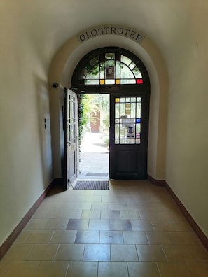 An arched entrance with a sign reading "GLOB TROTER" leading to a tiled hallway.