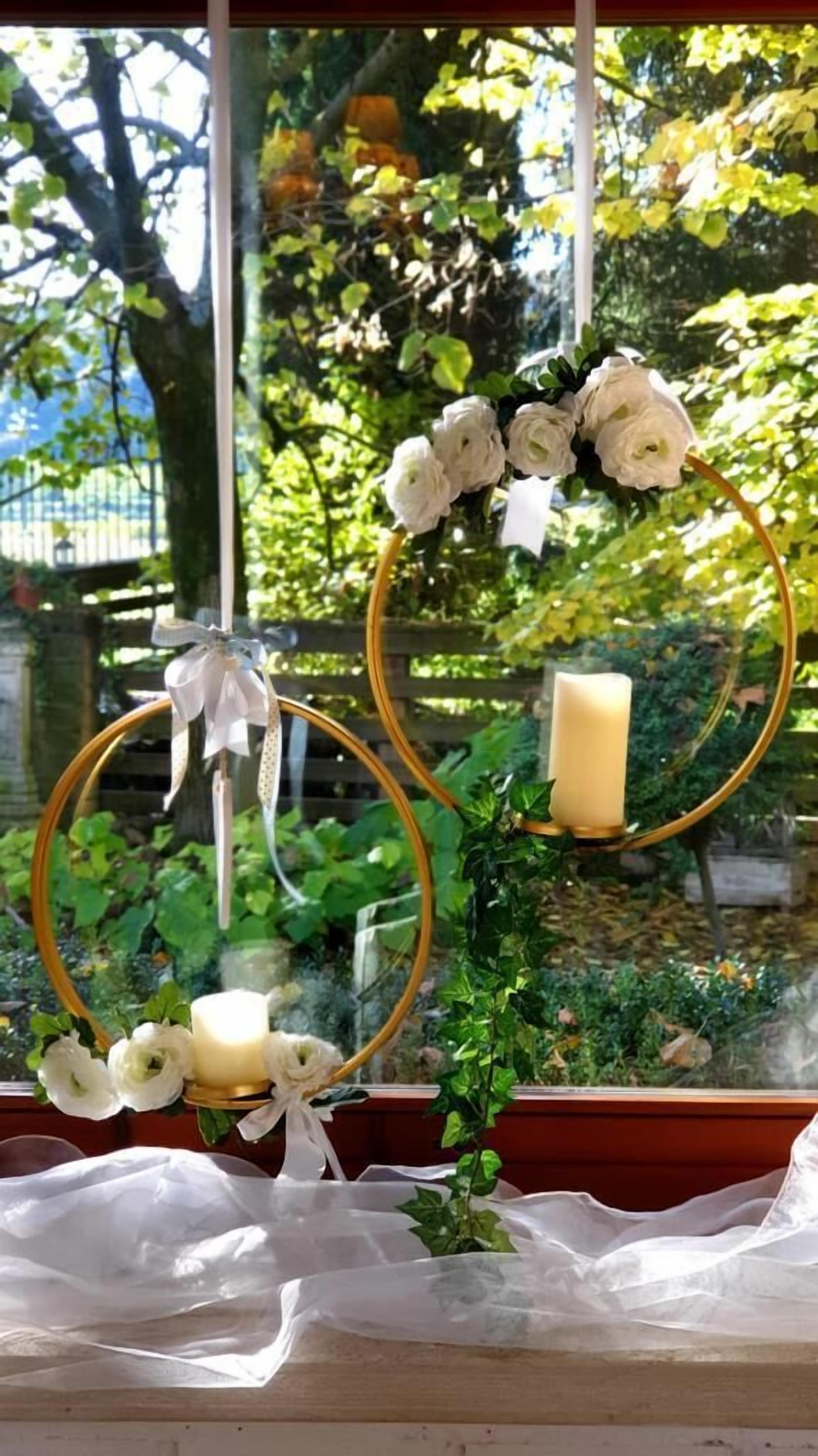 Ein Fenster mit einer dekorativen Anordnung aus weißen Blumen und Kerzen.