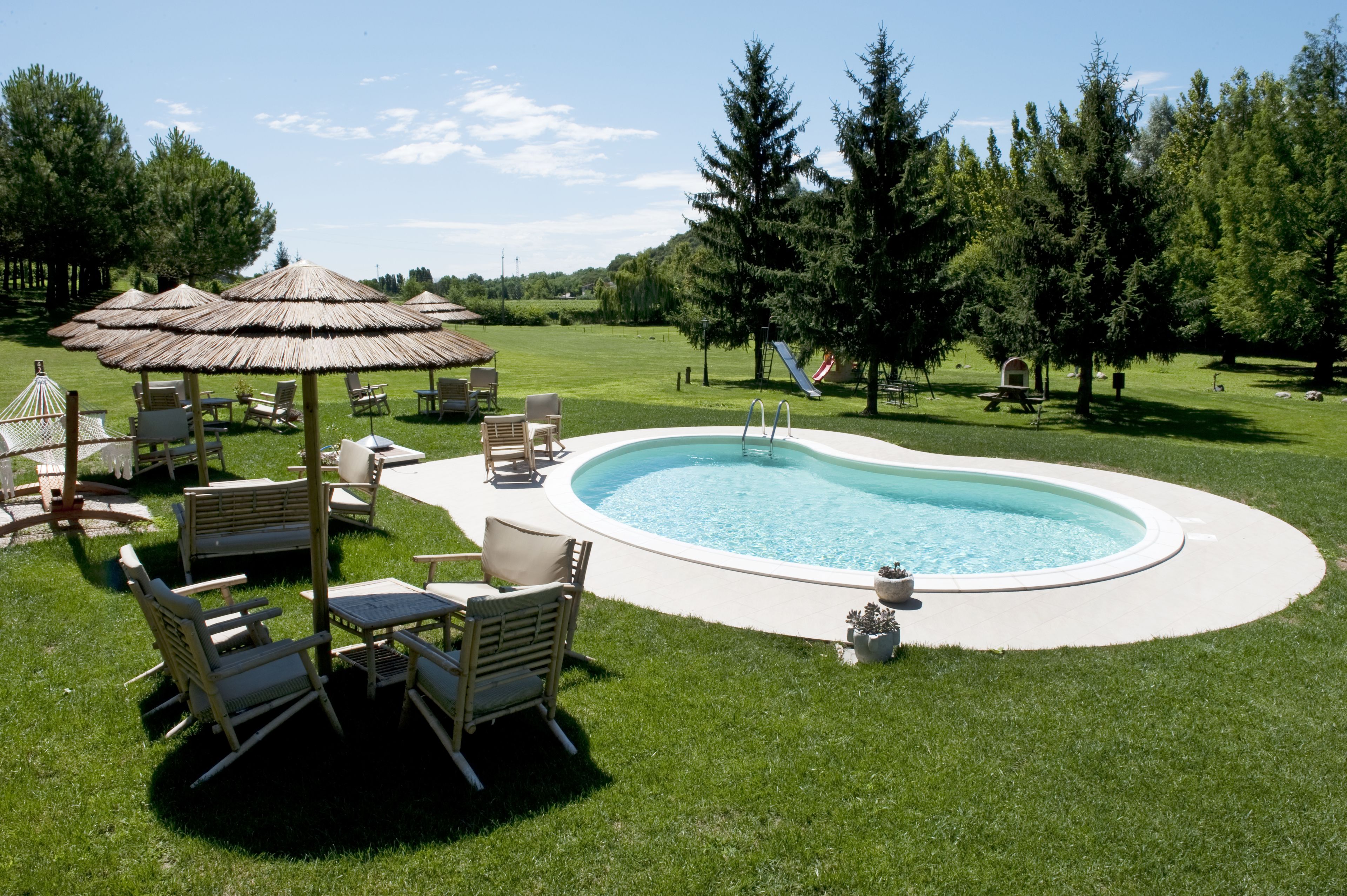 Una piscina al aire libre de temporada, sombrillas