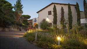 A building with a garden in front, a paved road, and a clear sky. - Hotel Fontermosa (Orbetello)