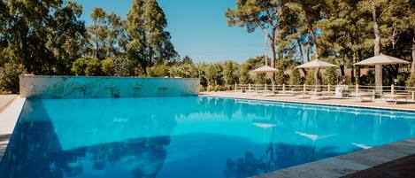 Piscina a l'aire lliure de temporada, para-sols i gandules
