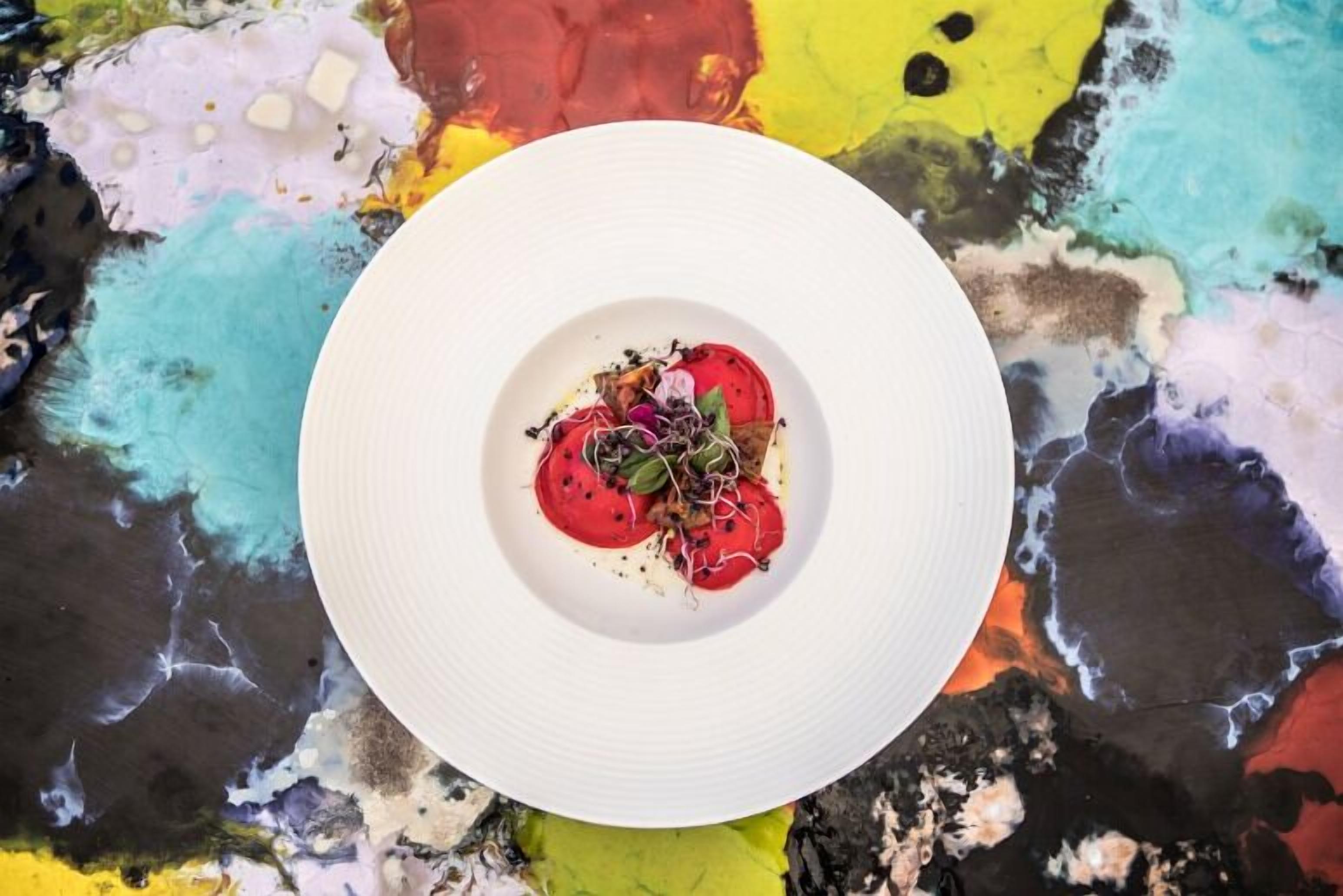 Un plato blanco con un fondo abstracto y colorido.