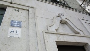 A building facade with a 'Sujeito Reboque' sign, a 'AL' sign, and the number '44'.